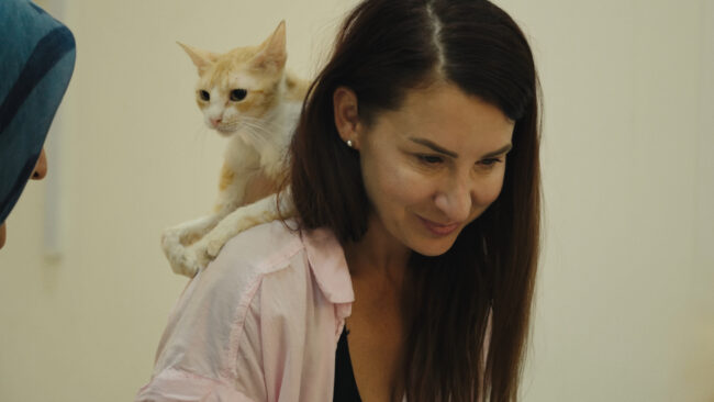 Mye Hoang's '25 Cats From Qatar' Are the Most Adorable Refugees 9 Katy McHugh with disabled kitty on shoulder in cat castle2_by Robert Bennett